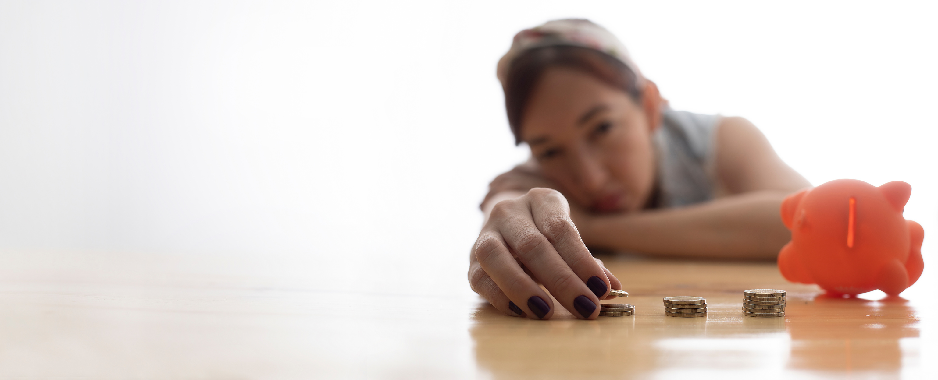 woman leaning on the table looking at coins, scarcity concept